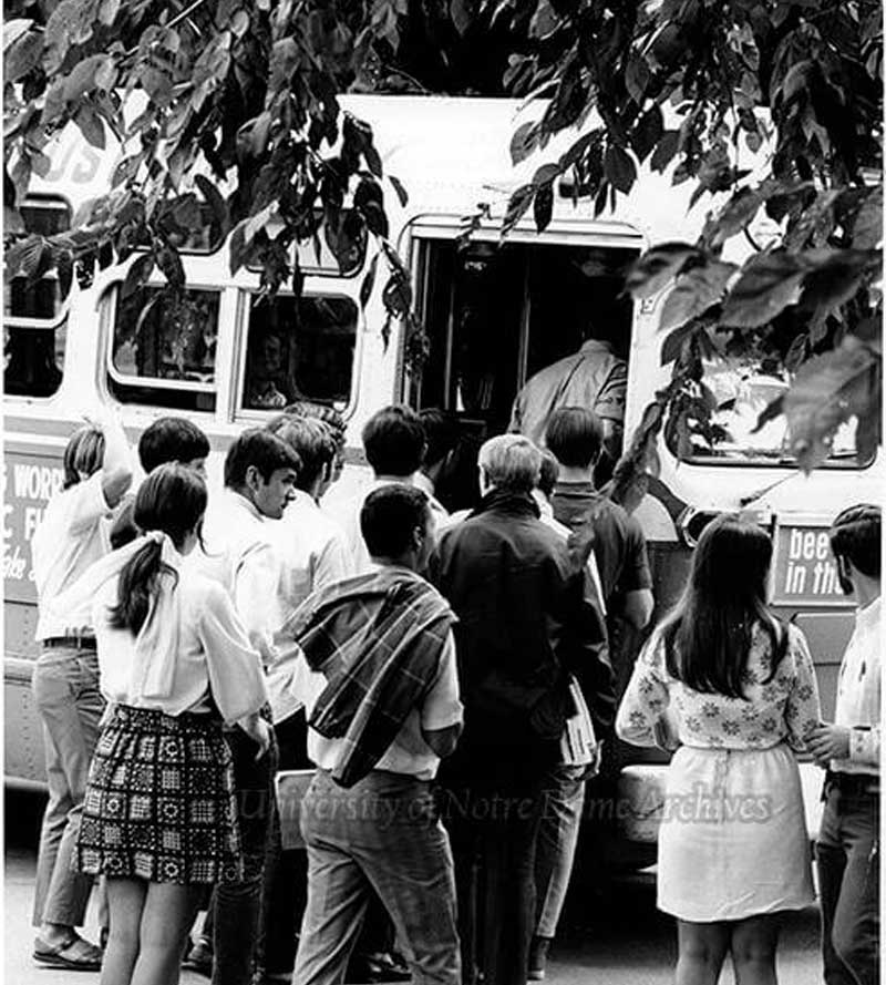 A group of students get on a bus.
