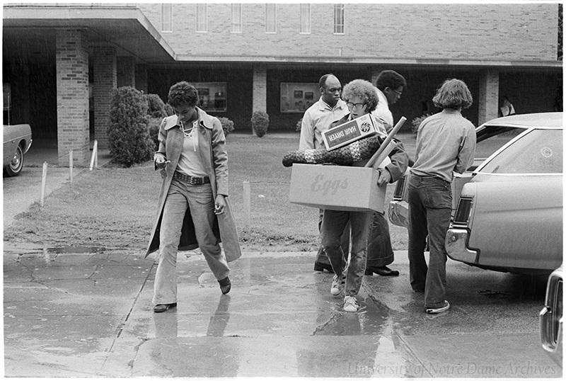 Female students unload boxes from a car on move in day.