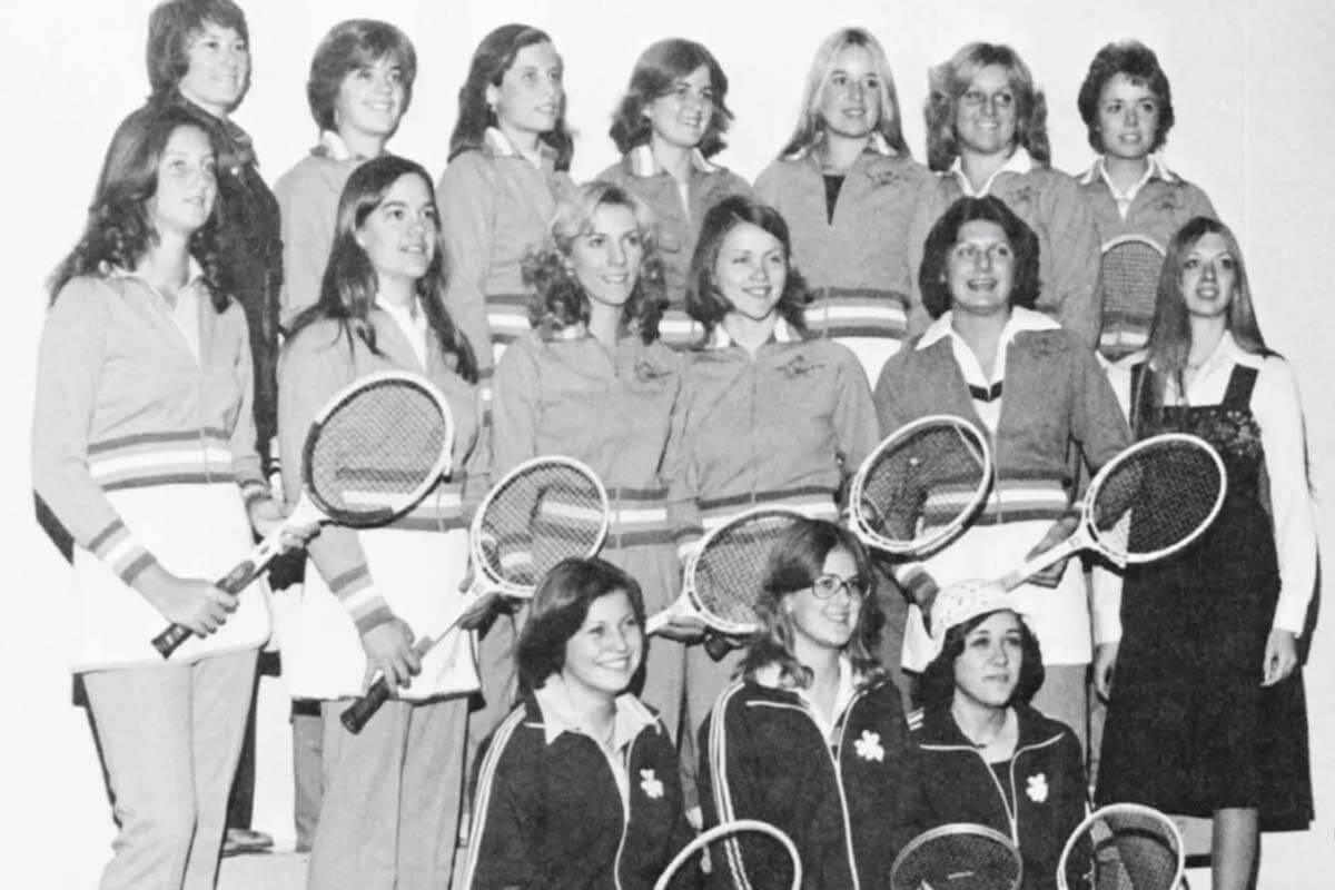 A black and white photo of Notre Dame women tennis players with their rackets.